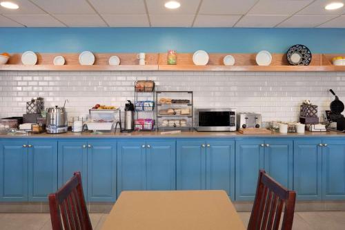 a kitchen with blue cabinets and a counter top at Country Inn & Suites by Radisson, Aiken, SC in Aiken