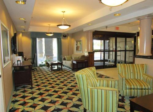 Country Inn & Suites by Radisson, Murrells Inlet, SC في ميرتل بيتش: لوبي وبه كرسيين وغرفة معيشة