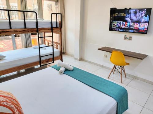 a room with two bunk beds and a yellow chair at Bona Vida Hotel in Ríohacha