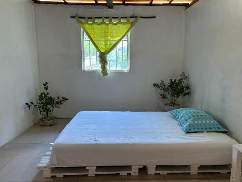 a bedroom with a bed in a room with a window at Punta Arena EcoHostal & EcoFit 03 in Playa Punta Arena