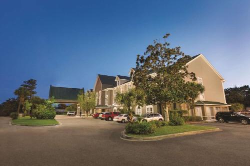 a large building with cars parked in a parking lot at Country Inn & Suites by Radisson, Beaufort West, SC in Beaufort