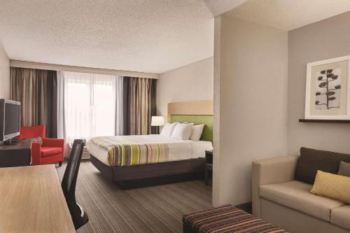 a hotel room with a bed and a couch at Country Inn & Suites by Radisson, Beaufort West, SC in Beaufort