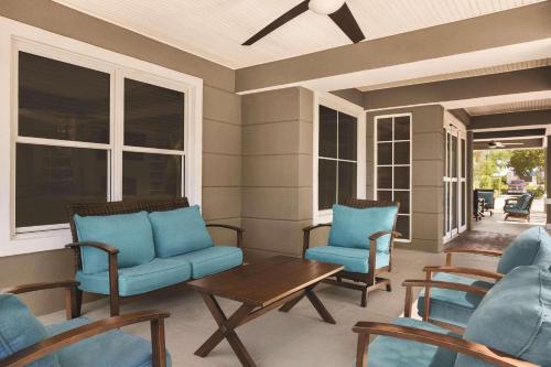 a screened in porch with blue chairs and a table at Country Inn & Suites by Radisson, Beaufort West, SC in Beaufort