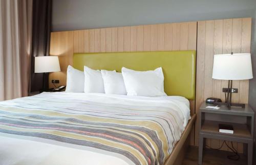 a bed in a hotel room with two lamps at Country Inn & Suites by Radisson, Myrtle Beach, SC in Myrtle Beach