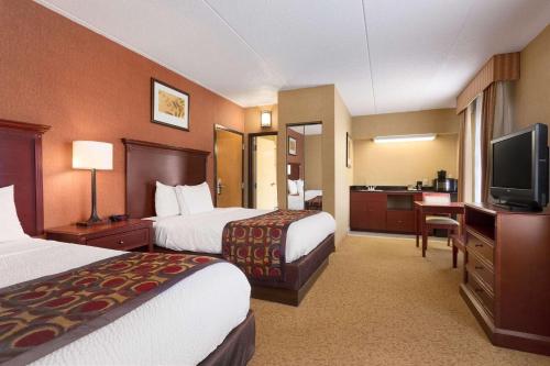 a hotel room with two beds and a flat screen tv at Country Inn & Suites by Radisson, Nashville Airport, TN in Nashville
