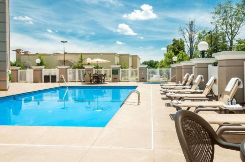 a pool with chaise lounge chairs next to a building at Country Inn & Suites by Radisson, Cookeville, TN in Cookeville