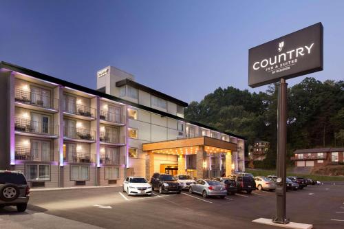 a hotel with cars parked in front of a parking lot at Country Inn & Suites Downtown Convention Center by Radisson, Gatlinburg, TN in Gatlinburg