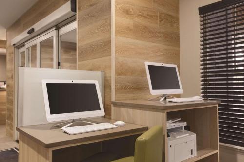 two computer monitors on a desk with a chair at Country Inn & Suites by Radisson, Chattanooga-Lookout Mountain in Chattanooga