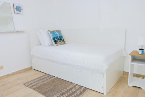 - un lit blanc dans une chambre avec une table dans l'établissement EL Bonito II Juan Dolio DR 2 room sleeps6 1queen bed 2twin bed 1sofa bed, à Juan Dolio