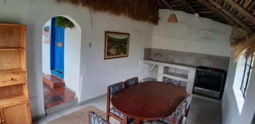 a dining room with a table and a blue door at Hacienda Yanahurco in Ovejería