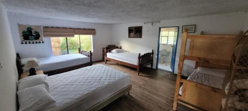 een slaapkamer met 2 bedden en een raam bij Hacienda Yanahurco in Ovejería