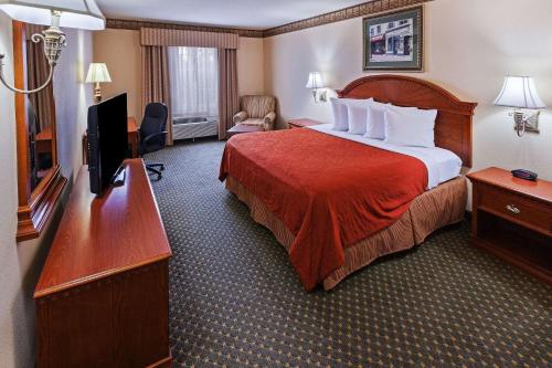 アマリロにあるCountry Inn & Suites by Radisson, Amarillo I-40 West, TXのベッド1台、薄型テレビが備わるホテルルームです。