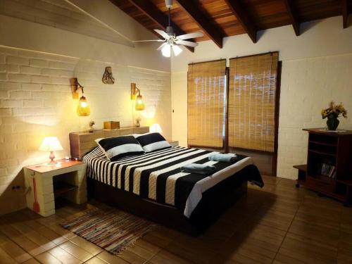 Casa de campo Villa Siles في بوكوسانا: غرفة نوم بسرير كبير ومروحة سقف