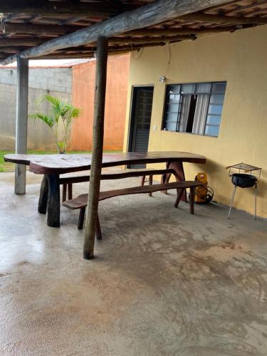une grande table de pique-nique en bois devant un bâtiment dans l'établissement Casa Para Temporada Guilherme, à Vargem Bonita