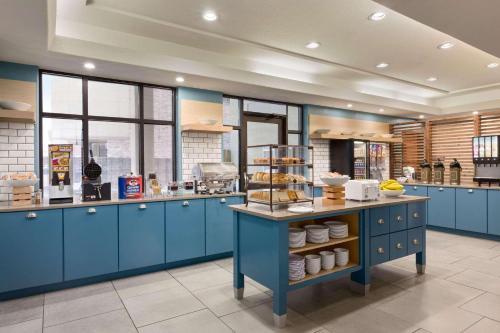 a kitchen with blue cabinets and a counter with food at Country Inn & Suites by Radisson, Houston Northwest, TX in Houston