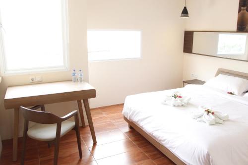 En eller flere senge i et værelse på AZKA HOTEL Managed by Salak Hospitality