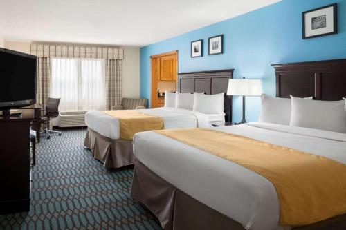 Country Inn & Suites by Radisson, Lubbock, TX في لوبوك: غرفة فندقية بسريرين وتلفزيون بشاشة مسطحة
