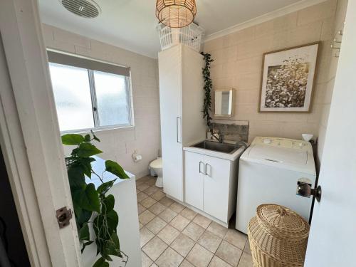 a small laundry room with a washer and a sink at The J's - Pets welcome outside in Robe