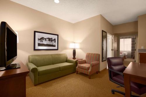 a living room with a couch and a television at Country Inn & Suites by Radisson, Houston Intercontinental Airport East, TX in Humble