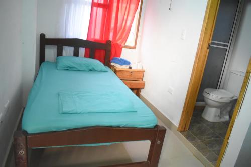 ein kleines Schlafzimmer mit einem Bett und einem WC in der Unterkunft Shaddai restaurante y hospedaje in Puerto Triunfo
