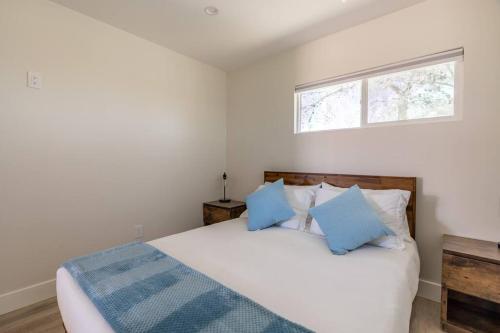 a bedroom with a large bed with blue pillows at The Invisible Wind Cabin- Joshua Tree Amazing View in Yucca Valley