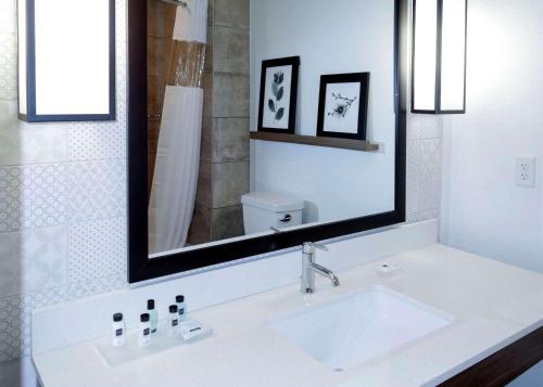 uma casa de banho branca com um lavatório e um espelho em Country Inn & Suites by Radisson, New Braunfels, TX em New Braunfels