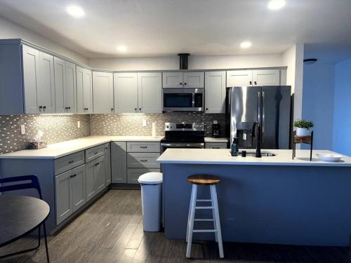 uma grande cozinha com armários brancos e uma ilha azul em Hidden Gem in Downtown Tacoma em Tacoma