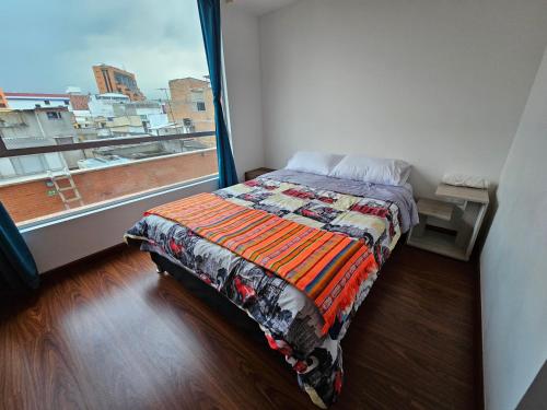 a bedroom with a bed and a large window at 2 habitaciones en centro de pasto parqueadero y baño privado in Pasto