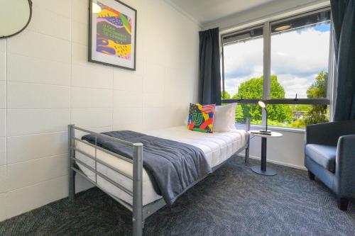 a small bedroom with a bed and a window at Urban Lounge Sleepery in Rotorua