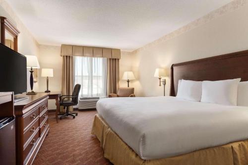 um quarto de hotel com uma cama grande e uma televisão em Country Inn & Suites by Radisson, Potomac Mills Woodbridge, VA em Woodbridge