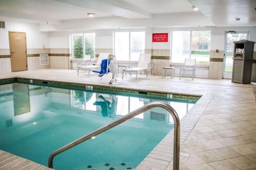 una piscina en un hospital con sillas y mesas en Country Inn & Suites by Radisson, Richmond West at I-64, VA, en Richmond