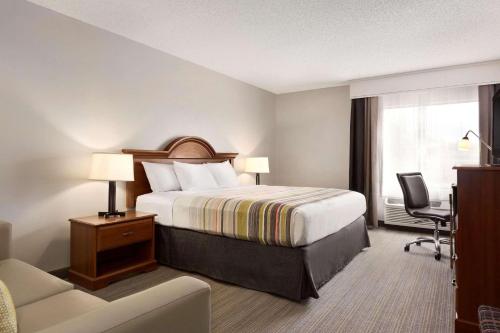 a hotel room with a bed and a desk at Country Inn & Suites by Radisson, Dahlgren-King George, VA in Dahlgren