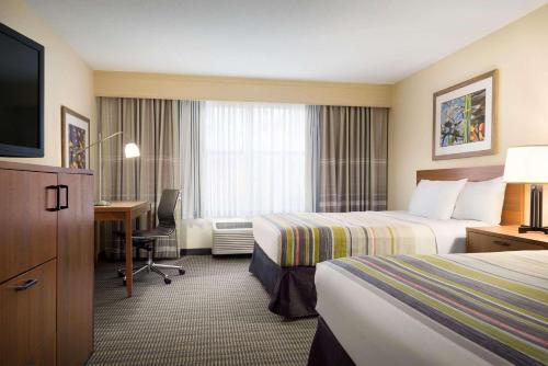 Habitación de hotel con 2 camas y escritorio en Country Inn & Suites by Radisson, Williamsburg Historic Area, VA en Williamsburg