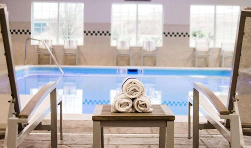 Country Inn & Suites by Radisson, Winchester, VA في وينشستر: وجود منشفة على طاولة أمام المسبح