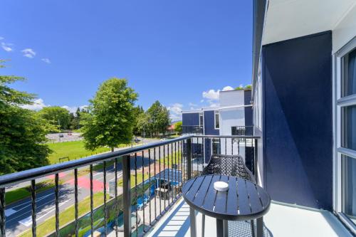 a balcony with a table and a view of a street at Urban Lounge Sleepery in Rotorua