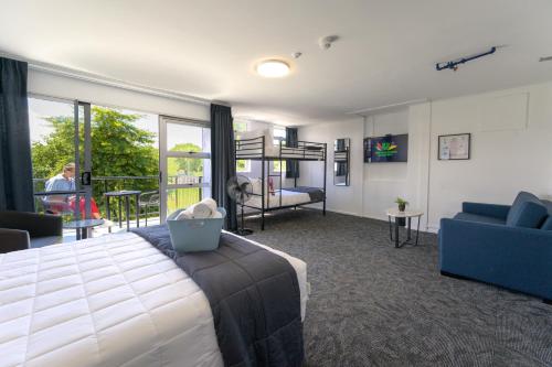 a bedroom with a bed and a living room at Urban Lounge Sleepery in Rotorua