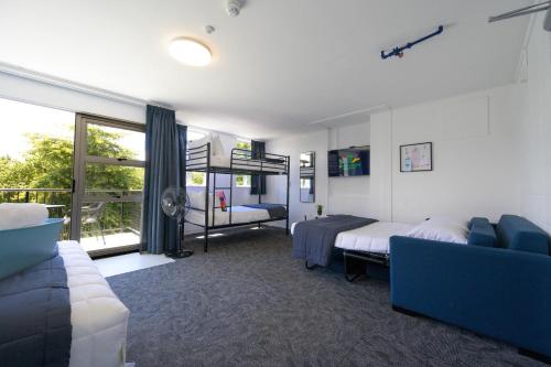 a bedroom with a bed and a couch at Urban Lounge Sleepery in Rotorua
