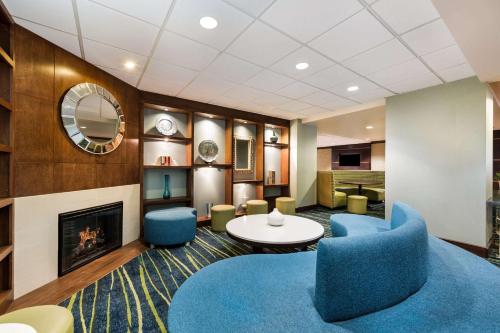 a lobby with blue chairs and a fireplace at Country Inn & Suites by Radisson, Virginia Beach Oceanfront , VA in Virginia Beach