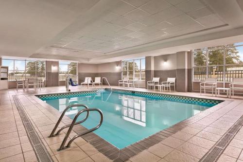 una gran piscina en un hotel con sillas y mesas en Country Inn & Suites by Radisson, Petersburg, VA, en Petersburg