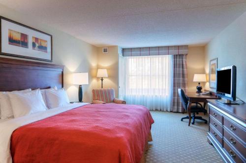 Una habitación de hotel con una cama y un escritorio con televisión. en Country Inn & Suites by Radisson, Fredericksburg, VA, en Fredericksburg