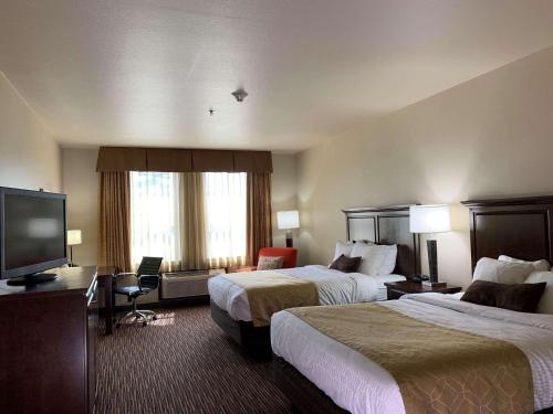 a hotel room with two beds and a flat screen tv at Radisson Hotel River Falls in River Falls