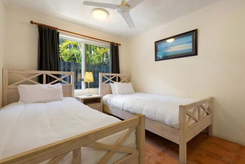 two beds in a room with a window at A Perfect Stay - Clarkes Beach Villa in Byron Bay