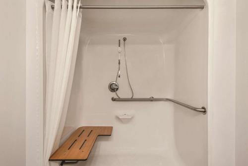 baño con banco de madera y cortina en Country Inn & Suites by Radisson, Green Bay East, WI, en Green Bay