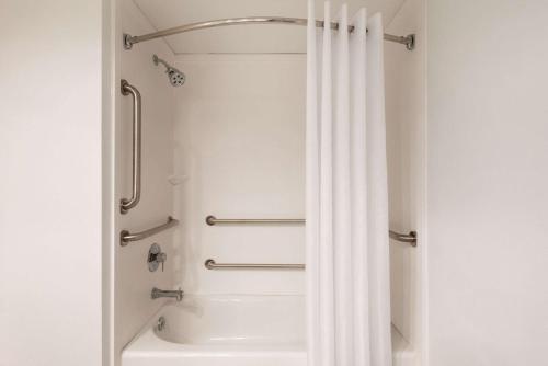 La salle de bains est pourvue d'une douche avec un rideau de douche blanc. dans l'établissement Country Inn & Suites by Radisson, La Crosse, WI, à La Crosse