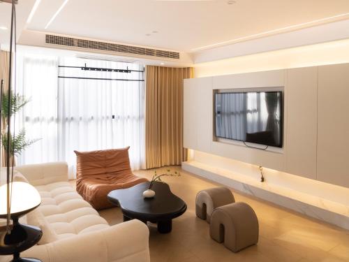 uma sala de estar com um sofá e uma televisão em Three Bedroom Apartment near Xintiandi em Xangai