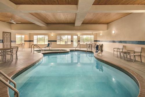 una piscina en un hotel con mesas y sillas en Country Inn & Suites by Radisson, West Bend, WI, en West Bend
