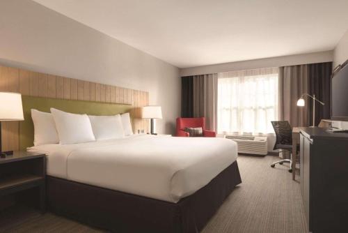 Pokój hotelowy z dużym łóżkiem i biurkiem w obiekcie Country Inn & Suites by Radisson, Germantown, WI w mieście Germantown