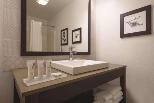 W łazience znajduje się biała umywalka i lustro. w obiekcie Country Inn & Suites by Radisson, Germantown, WI w mieście Germantown
