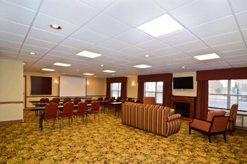 a conference room with chairs and a table and a podium at Country Inn & Suites by Radisson, Stevens Point, WI in Stevens Point