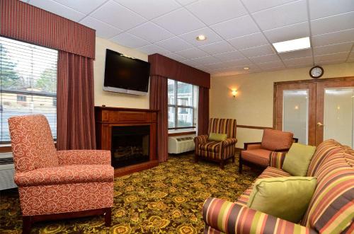 a waiting room with two chairs and a fireplace at Country Inn & Suites by Radisson, Stevens Point, WI in Stevens Point